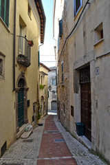 Fototapeta na wymiar Veroli, Italy, 01/03/2020. A narrow street between the old houses of a medieval village