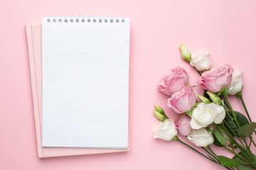 Beautiful white and pink roses flower and notebook on pastel background. Minimalistic composition for the holidays,valentines day and womens day.