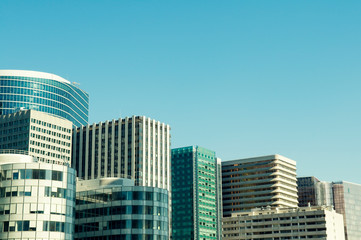 Abstract city skyline view of anonymous office towers under soft blue sky