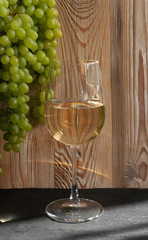 White Wine Glass on Ripe Green Grapes Background in Sunny Day