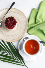 A cake and a cup of black tea on a white table. Restaurant serving. A look from above.