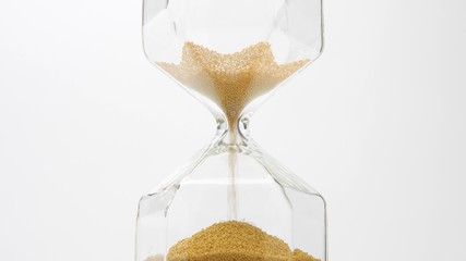glass sand clock on white with golden balls instead of sand falling. Deadline concept. Stress of time planing concept