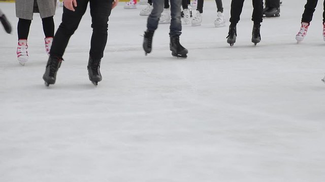 Tourists skate close-up on a large skating rink. Feet after skating which skating on a frozen lake.