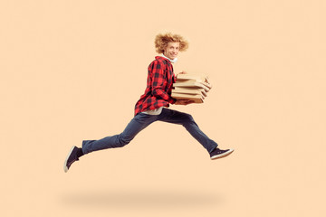 Young adult man running with carton pizza boxes in hands