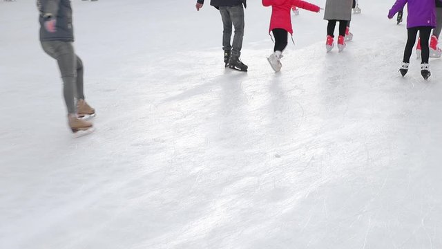 Tourists skate close-up on a large skating rink. Feet after skating which skating on a frozen lake.
