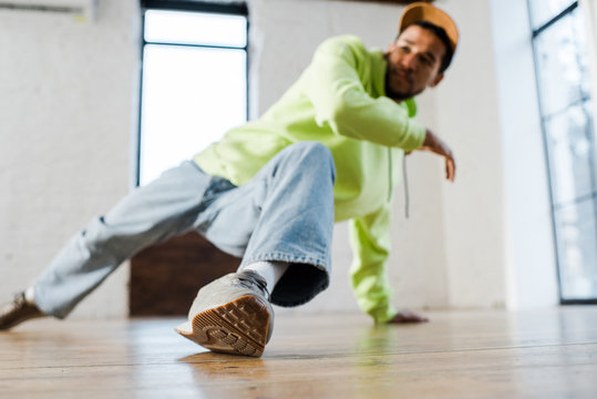 selective focus of stylish african american man in cap breakdancing in dance studio