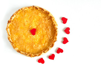 Apple pie decorated with hearts for Valentine day on a whit wooden background.