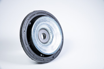 New thrust bearing of front suspension strut of a car on a gray background. The concept of new spare parts and replacement parts in service centers