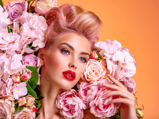 Beautiful white girl with flowers. Stunning blonde girl with big bouquet flowers of roses. Closeup face of young beautiful woman with a healthy clean skin. Pretty woman with bright makeup