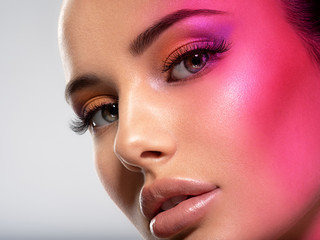 Beautiful white girl with bright eye-makeup. Beautiful fashion woman with  a red  flare on face.  ...