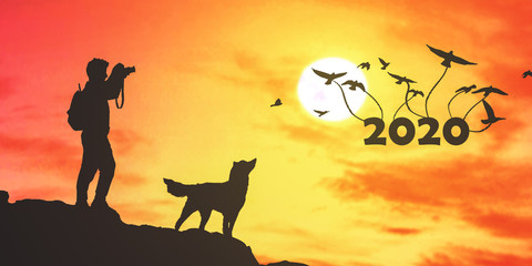 men with the dog on the top of the cliff and sunset background.