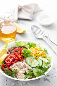 Chicken meat lunch bowl with fresh salad leaves, corn, cucumber, sweet pepper and quinoa