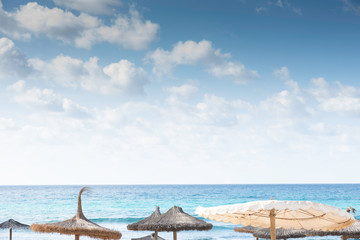 umbrellas on the beach with the sea in the background and sky with clouds
