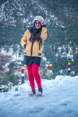 Fototapeta na wymiar Happy Indian Woman enjoying her first snowfall during winter holidays in India.