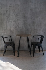 Black metal chairs and wooden table retro interior vintage decoration with concrete wall loft style