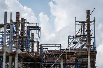 Building and Construction Site in progress. Building construction site against cloudy sky. Metal construction of unfinished building on construction of multi storage building.