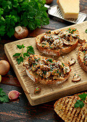 Grilled mushroom toast with parsley, lemon and parmesan cheese on wooden board. healthy vegan food
