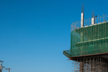 Building and Construction Site in progress. Building construction site against blue sky. Metal...