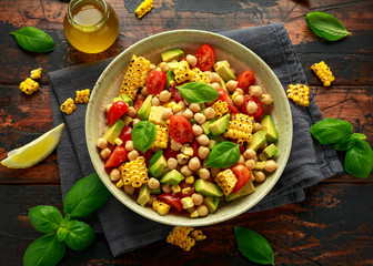Avocado chickpea salad with grilled sweet corn, tomato and basil. Healthy vegan food