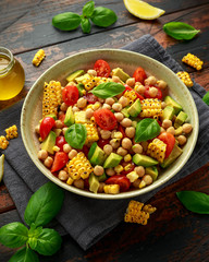 Avocado chickpea salad with grilled sweet corn, tomato and basil. Healthy vegan food