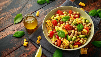 Avocado chickpea salad with grilled sweet corn, tomato and basil. Healthy vegan food