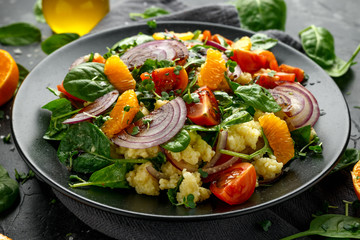 Vegetable Millet salad with red onion, cherry tomatoes, spinach, tangerine and clementine dressing. healthy food