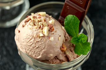 Chocolate Ice Cream with dark chocolate bars and hazelnuts in a glass bowl