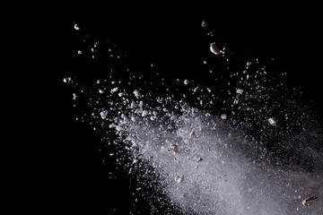 White powder explosion isolated on black background.