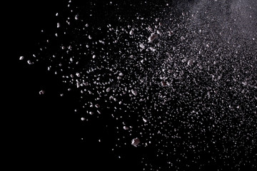 White powder explosion isolated on black background.