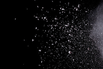 White powder explosion isolated on black background.
