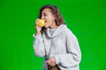 Healthy diet concept. Cute female bites apple, getting real pleasure, eating fresh and healthy food.