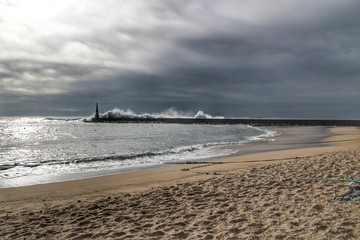 Giant waves breaking on the breakwater and the lighthouse