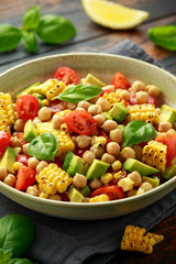 Avocado chickpea salad with grilled sweet corn, tomato and basil. Healthy vegan food