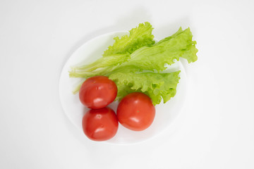 Close up of cherry tomatoes and lettuce on a white background. Healthy food.