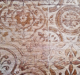 Fototapeta premium Brown ceramic tile with floral pattern for wall and floor decoration. Aged concrete stone surface background. Vintage texture for interior design project.