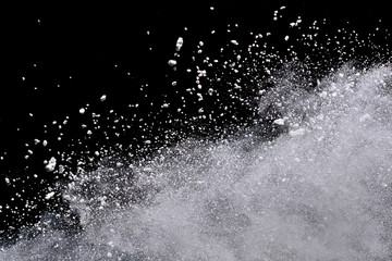 White powder explosion isolated on black background.