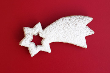 Romantic sugared cookie in a shape of comet on red background © Martina