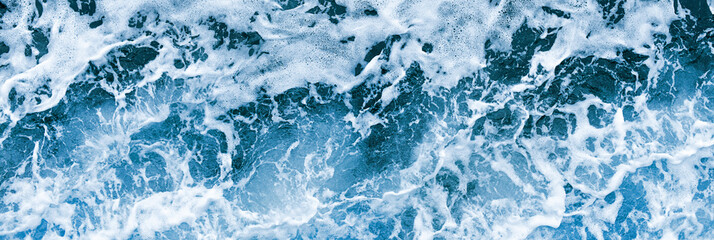 Aerial view of salt ocean waves. Blue water aqua sea background ot texture. Rippled spashing waves wide banner panoramatic photo.