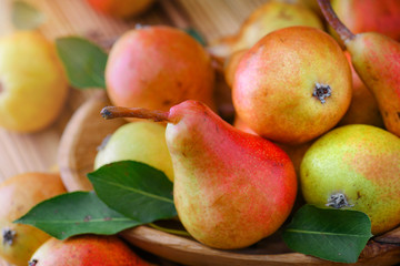 Fresh pears on wooden background. Red yellow pear fruits at the table.