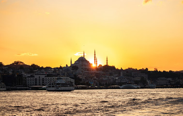 Sunset panorama of Istanbul at the golden hour, Sultan mosque visible as the sun goes down, golden yellow sky
