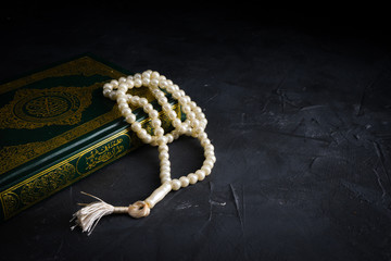 Faith in Islam concept. The Islamic holy book, Quran or Kuran, with rosary beads or “tasbih” on...