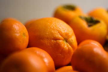 Orange fruits close-up. Oranges, tangerines and persimmons.
