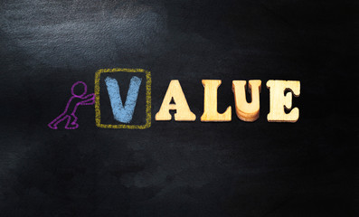 forming value concept with wooden letters  and chalkboard 