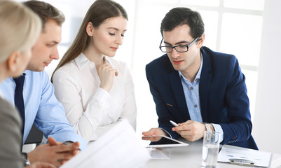 Fototapeta premium Group of business people discussing questions at meeting in modern office. Managers at negotiation or brainstorm. Teamwork, partnership and business concept