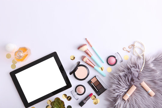 cosmetics and modern tablet on a colored background top view. Beauty blog concept.
