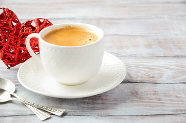 Cup of fresh morning coffee on a wooden background. Valentine's day concept.