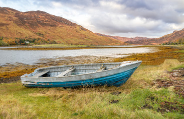 A small boat beached on the side of Loch Long near Dornie in the Highlands of Scotland