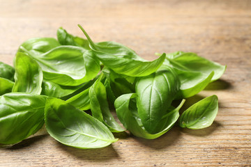 Fresh basil leaves on wooden table, closeup