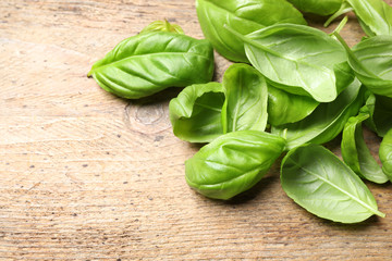 Fresh basil leaves on wooden table, closeup
