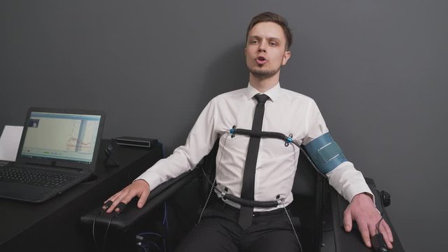 Bearded man passing check on polygraph machine in office